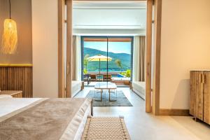 1 dormitorio con cama y vistas a la piscina en La Blanche Island Bodrum en Guvercinlik