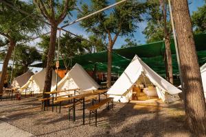 a group of tents with tables and benches in a field at Kampaoh Costa del Sol in Caserío Almayate Bajo