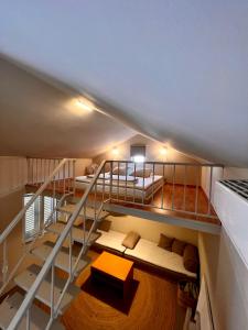 a loft room with a staircase with a bed and a couch at Apartments Zore Dubrovnik in Dubrovnik