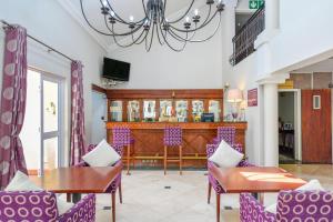 a dining room with purple chairs and a table at Mercure Johannesburg Randburg in Johannesburg