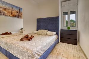 a bedroom with a large bed with a blue headboard at Modern apartment with an addictive terrace view in Los Cristianos
