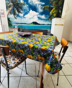 una mesa de comedor con un mantel con naranjas. en Come a casa tua en Falconara Marittima