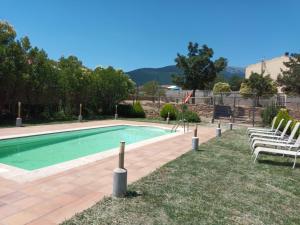 una piscina con 2 sillas de jardín junto a ella en Hotel Restaurante Comendador Añon de Moncayo, en Añón