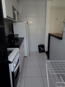 uma cozinha com um fogão e um frigorífico branco em AP - Arretado em Campina Grande