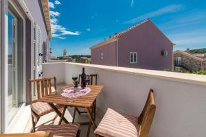 un piccolo balcone con tavolo e sedie in legno di Apartments Lana a Mlini