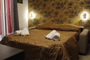 Una habitación de hotel con una cama con toallas. en La pergola home, en Barletta