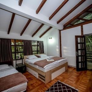 a bedroom with two beds in a room with windows at Vikendica za odmor Ušće in Banja Luka
