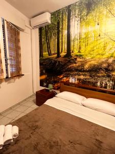 una camera da letto con un dipinto di una foresta di Come a casa tua a Falconara Marittima