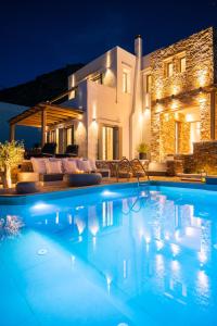 a swimming pool in front of a house at night at VILLA DIMAR SIFNOS in Kamares