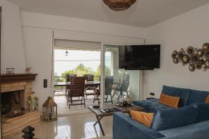 a living room with a blue couch and a fireplace at NisoVillas in Volos