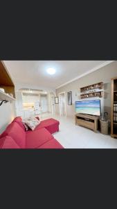 a living room with a red couch and a large screen tv at Balcon Mar Larisa in Costa Del Silencio +18 photos
