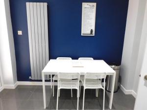 una mesa y sillas blancas en una habitación con una pared azul en Beautiful 3 bedroom home with large garden 35 mins to Glasgow & Edinburgh en Whitburn