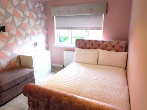 1 dormitorio con cama y ventana en Beautiful 3 bedroom home with large garden 35 mins to Glasgow & Edinburgh en Whitburn