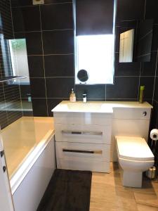 a bathroom with a white sink and a toilet at Beautiful 3 bedroom home with large garden 35 mins to Glasgow & Edinburgh in Whitburn