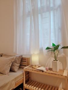 um quarto com uma cama e uma janela com uma planta sobre uma mesa em DAISY'S STAY em Hanói