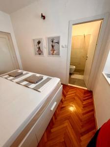 a bedroom with a bed and a bathroom with a toilet at Apartments Zore Dubrovnik in Dubrovnik