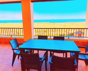 uma mesa azul e cadeiras com vista para a praia em Los Pelícanos, Isla Canela By AC REAL na Isla Canela