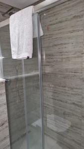 a shower with a glass door and a towel at Le luxe de Ain zaghouan in Sidi Daoud