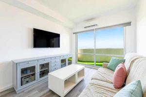 un soggiorno con divano e TV a schermo piatto di BENALBEACH APARTAMENTO con vistas maravillosas a Málaga