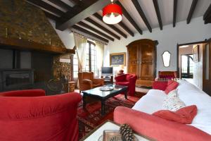 sala de estar con muebles de color rojo y chimenea en Bernet, en Labastide-Villefranche