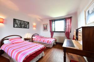 1 dormitorio con 2 camas y ventana en Bernet, en Labastide-Villefranche
