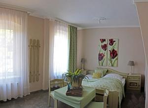 ein Schlafzimmer mit einem Bett und einem Tisch mit einem sidx sidx in der Unterkunft Hotel & Restaurant Eggers GmbH in Sprockhövel