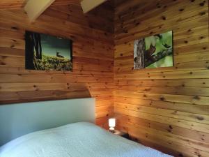 a bedroom with wooden walls and a bed in a room at bois de biron - gîte - vakantiehuis - chalet in Érezée