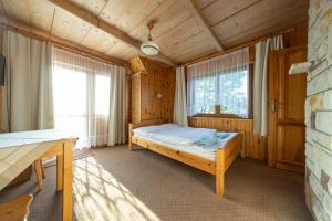 a bedroom with a bed in a wooden room at Willa Krokus in Zakopane