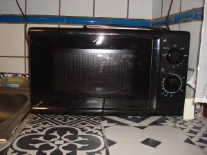 a microwave oven sitting on top of a kitchen floor at Chalet appartement in Lille