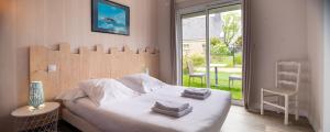 1 dormitorio con 1 cama con toallas en Hôtel Restaurant La Voile Bleue, en Erdeven