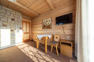 a room with a table and chairs and a tv at Willa Krokus in Zakopane