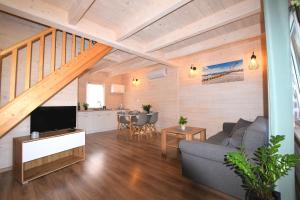 a living room with a couch and a tv at Domki Perłowe in Dąbki