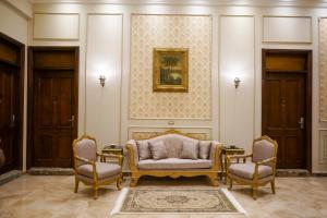 Savoy Hotel ELMinya في المنيا: غرفة معيشة مع أريكة وكرسيين