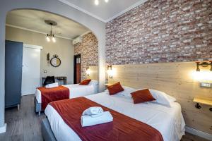 a hotel room with two beds and a brick wall at HOTEL VENETO con accesso ZTL in Florence