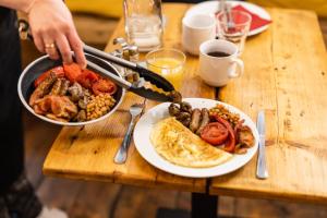 a table with a plate of food and a pan of breakfast foods at Sophie's Hostel in Prague
