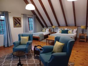 伯格威爾的住宿－德拉肯斯堡山度假酒店，一间客房配有两张床、两把椅子和一张沙发