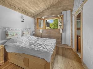 a bedroom with a bed and a window at Duplex 7 pers proche base de loisirs Carroz (ACL06) in Les Carroz d'Araches