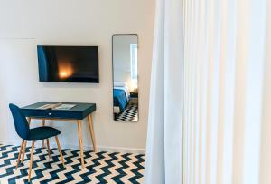 Habitación con escritorio, espejo y cama. en Davalos 14 Luxury Home, en Isquia