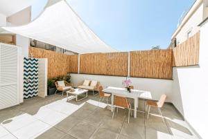 un patio con una mesa blanca y sillas en Davalos 14 Luxury Home, en Isquia