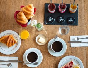 a table topped with cups of coffee and pastries at Hôtel Restaurant La Voile Bleue in Erdeven