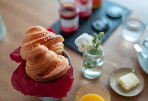 a table with a plate of bread and a vase of flowers at Hôtel Restaurant La Voile Bleue in Erdeven