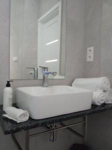 a bathroom with a sink and a mirror and towels at Szarga in Lubiatowo