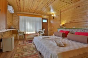 a bedroom with a bed in a wooden room at Çıralı Orange Motel in Cıralı