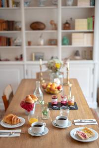 a table with croissants and breakfast foods on it at Hôtel Restaurant La Voile Bleue in Erdeven