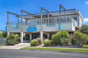 a large white building with a balcony on a street at The Apollo in Apollo Bay