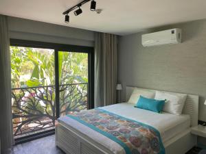 sypialnia z łóżkiem oraz balkon z oknem w obiekcie Villa Oliva Butik Hotel w Bodrum