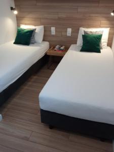 two twin beds in a room with a table at Szarga in Lubiatowo