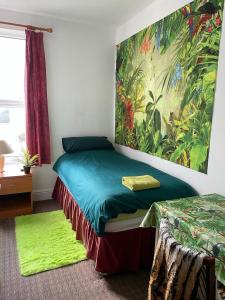 Schlafzimmer mit einem Bett mit Wandgemälde in der Unterkunft The Blue Moon in Blackpool
