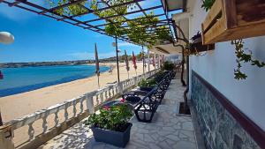 a row of tables and chairs next to a beach at CASA DEL SOL Sozopol in Sozopol