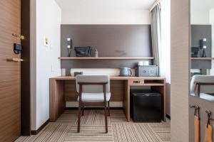 a room with a desk and a chair in a room at Hotel Sanrriott Osaka Hommachi in Osaka